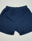 Navy kids shorts on a white background with seashells around